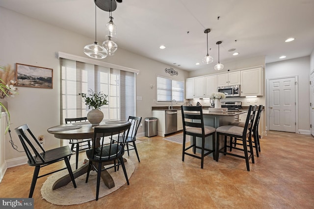 dining space featuring sink and light tile patterned flooring