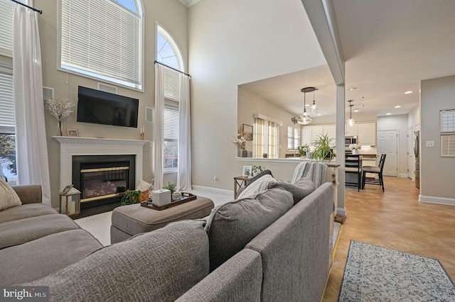 tiled living room with a high ceiling and an inviting chandelier