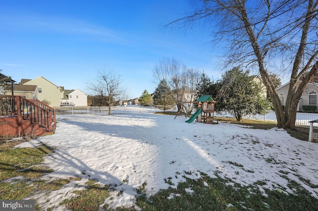 yard layered in snow featuring a playground