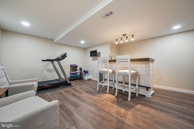 exercise area featuring track lighting and dark hardwood / wood-style floors