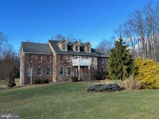 colonial-style house with a front yard and a balcony