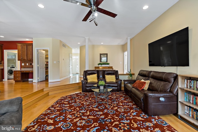 living room with light wood-style flooring, decorative columns, washer / dryer, and recessed lighting