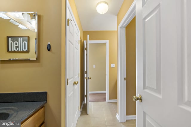 bathroom with baseboards, vanity, and tile patterned floors