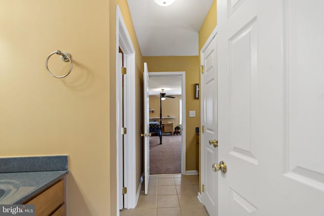 corridor with baseboards and light tile patterned floors