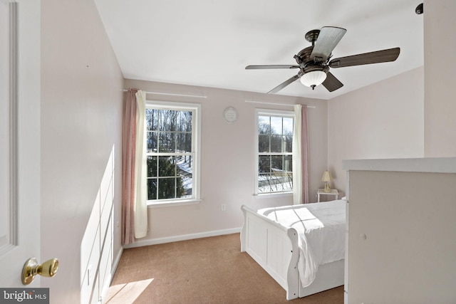 bedroom featuring baseboards, a ceiling fan, and light colored carpet