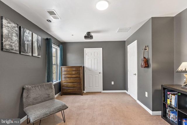 sitting room featuring baseboards, visible vents, and light colored carpet