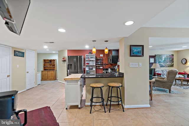 kitchen featuring a breakfast bar, a peninsula, stainless steel appliances, pendant lighting, and recessed lighting