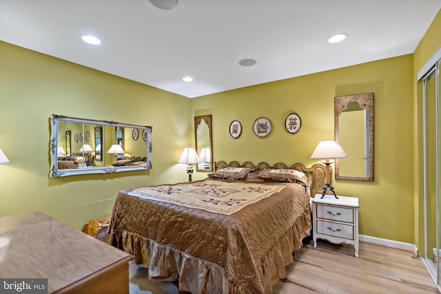 bedroom with baseboards, wood finished floors, and recessed lighting