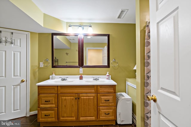 bathroom featuring double vanity, a sink, visible vents, and tile patterned floors