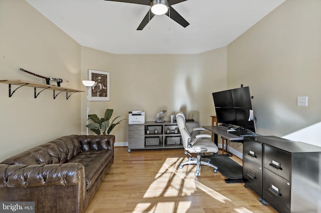 home office featuring light wood finished floors, baseboards, and a ceiling fan