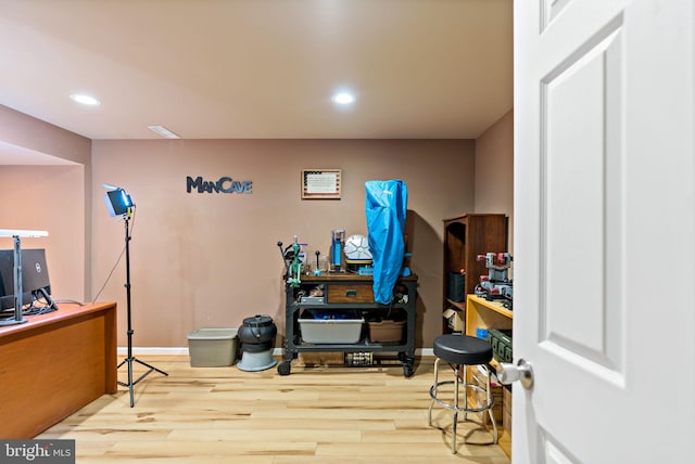 workout room featuring baseboards, wood finished floors, and recessed lighting