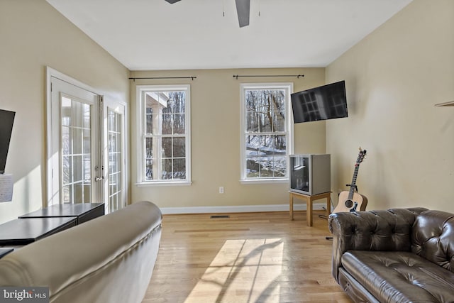 living area featuring ceiling fan, wood finished floors, and baseboards