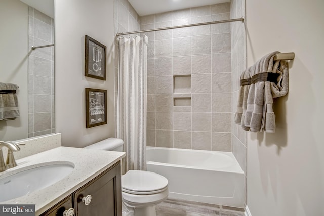 full bathroom with hardwood / wood-style flooring, shower / tub combo with curtain, vanity, and toilet