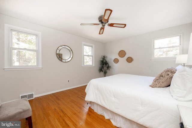 bedroom featuring multiple windows, ceiling fan, and light hardwood / wood-style floors