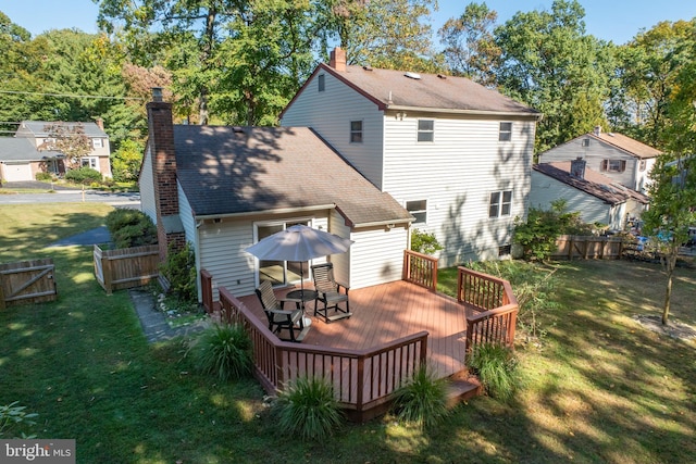 back of property featuring a yard and a wooden deck