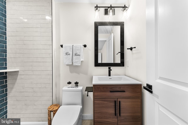 bathroom with vanity, toilet, and a tile shower