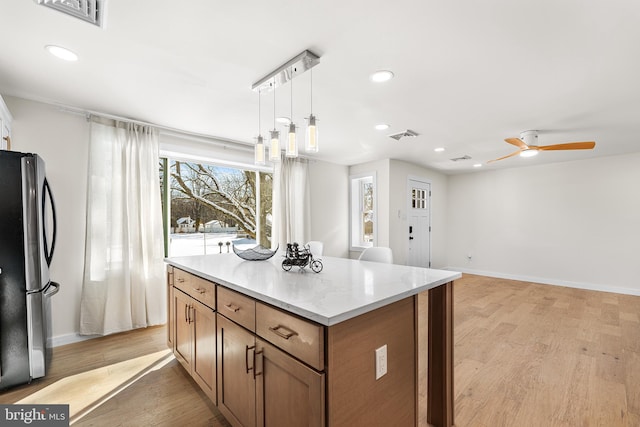 kitchen with stainless steel refrigerator, ceiling fan, light hardwood / wood-style flooring, and pendant lighting