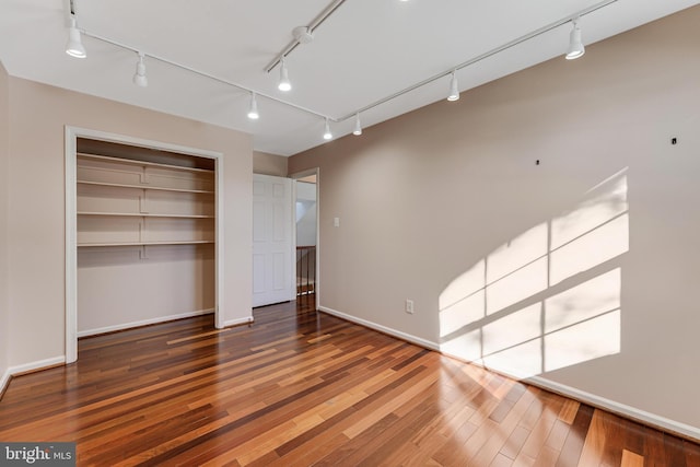 unfurnished bedroom with dark wood-type flooring and a closet