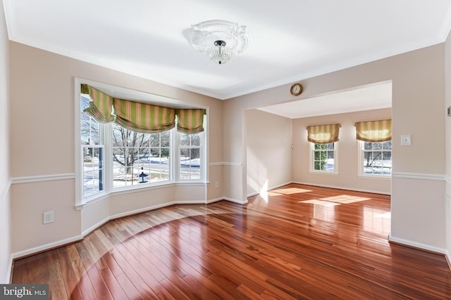 empty room with wood-type flooring and ornamental molding