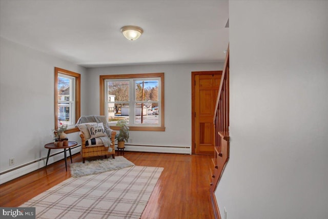 sitting room with baseboard heating and light wood-type flooring