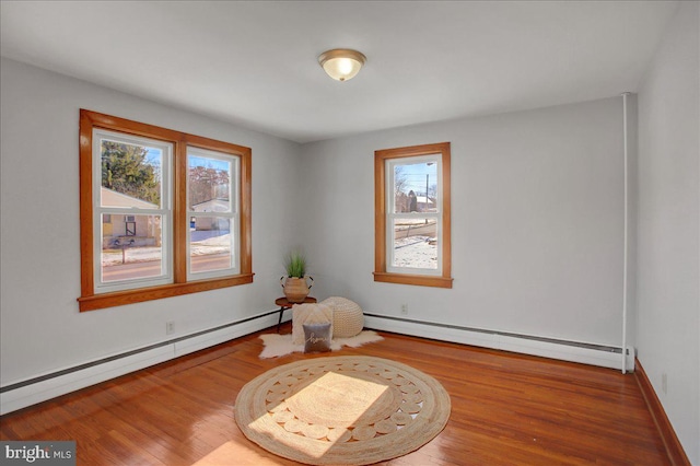 living area with hardwood / wood-style flooring and a baseboard radiator