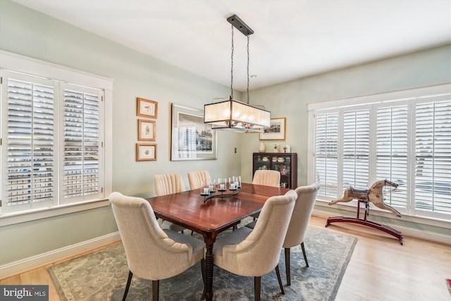 dining area with wood-type flooring and an inviting chandelier