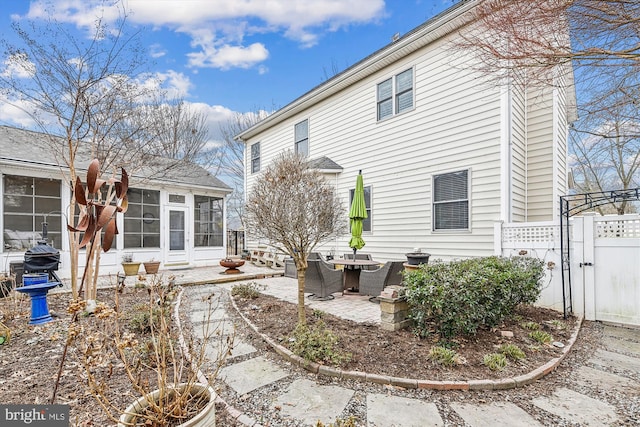 rear view of property featuring a patio and a sunroom