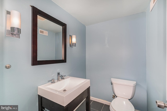 bathroom featuring toilet, tile patterned floors, and vanity