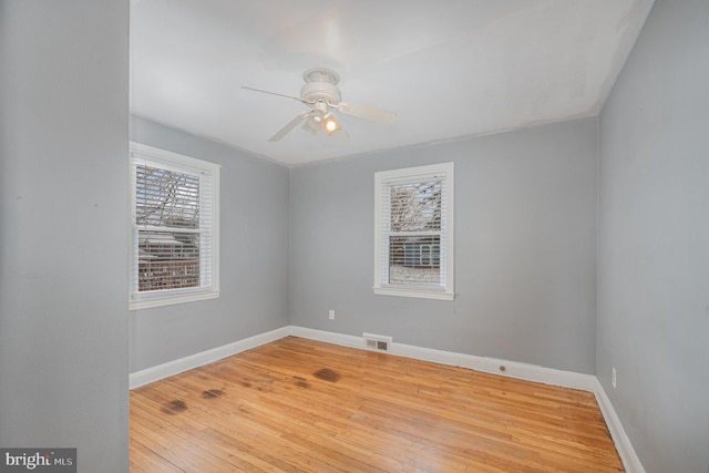 empty room featuring ceiling fan, light wood-type flooring, and plenty of natural light