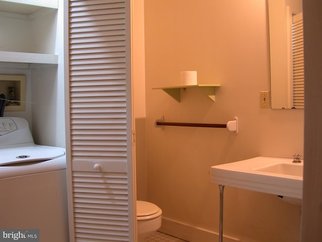 bathroom with tile patterned floors, toilet, and washer / clothes dryer