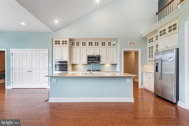 kitchen featuring high vaulted ceiling, a kitchen island with sink, and appliances with stainless steel finishes