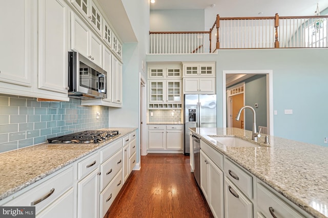 kitchen featuring light stone counters, dark hardwood / wood-style flooring, white cabinetry, appliances with stainless steel finishes, and sink