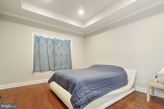 bedroom featuring dark wood-type flooring and a tray ceiling