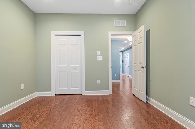 unfurnished bedroom with a closet and hardwood / wood-style floors