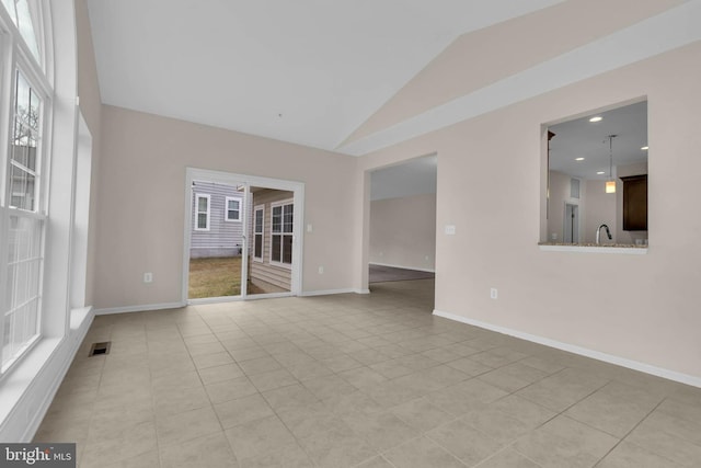 unfurnished room featuring vaulted ceiling, light tile patterned floors, visible vents, and baseboards