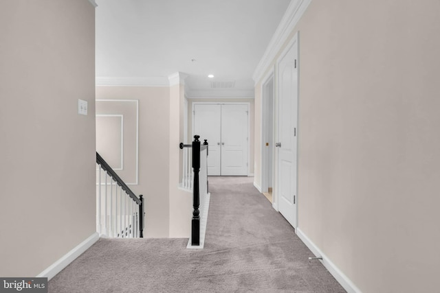 corridor featuring carpet floors, baseboards, ornamental molding, and an upstairs landing