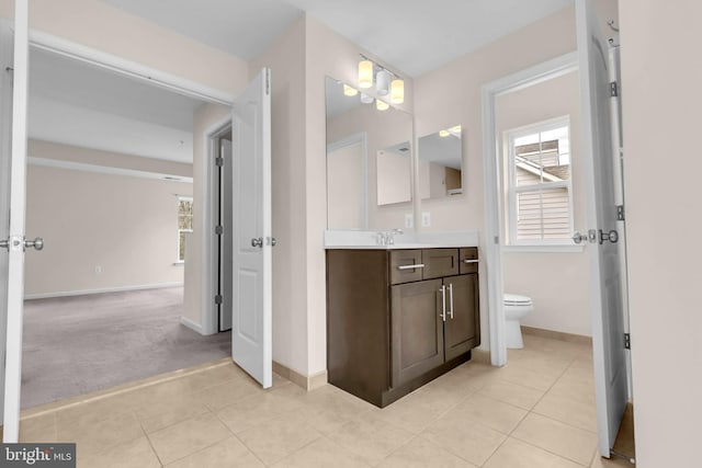 bathroom featuring baseboards, vanity, toilet, and tile patterned floors