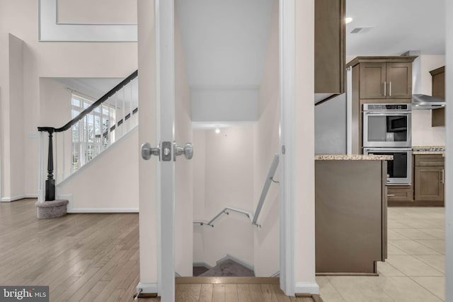 stairs featuring visible vents, baseboards, and wood finished floors