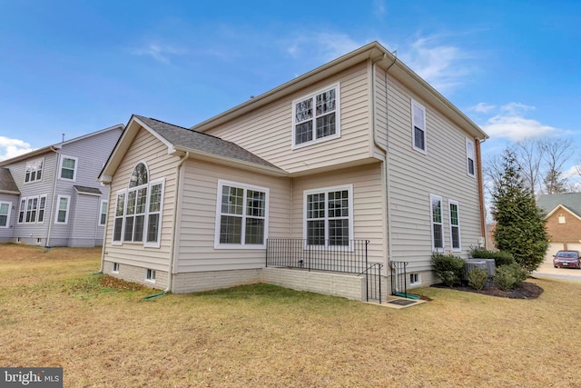 back of house with central AC and a lawn