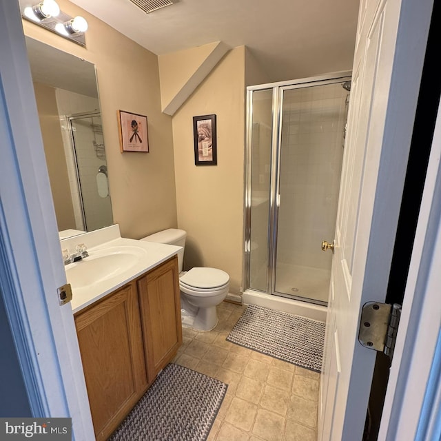 bathroom with a shower with door, vanity, and toilet