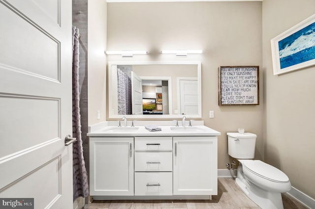 bathroom with hardwood / wood-style flooring, toilet, and vanity