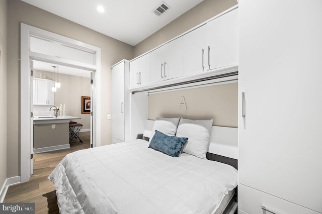 bedroom with light hardwood / wood-style floors and a closet