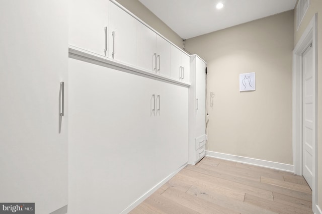 laundry area with light wood-type flooring