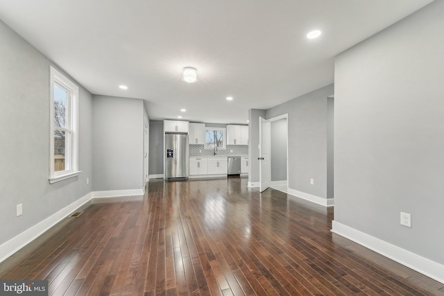 unfurnished living room with dark hardwood / wood-style floors and sink