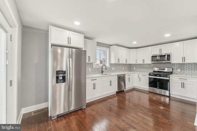 kitchen with sink, dark hardwood / wood-style floors, white cabinets, and appliances with stainless steel finishes