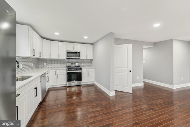 kitchen with tasteful backsplash, stainless steel appliances, sink, and white cabinets