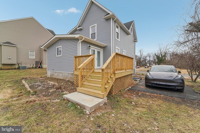 back of house with a wooden deck and central AC unit