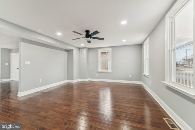 empty room featuring dark wood-type flooring and ceiling fan