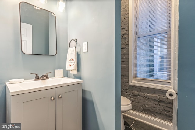 bathroom with toilet, tile patterned flooring, and vanity