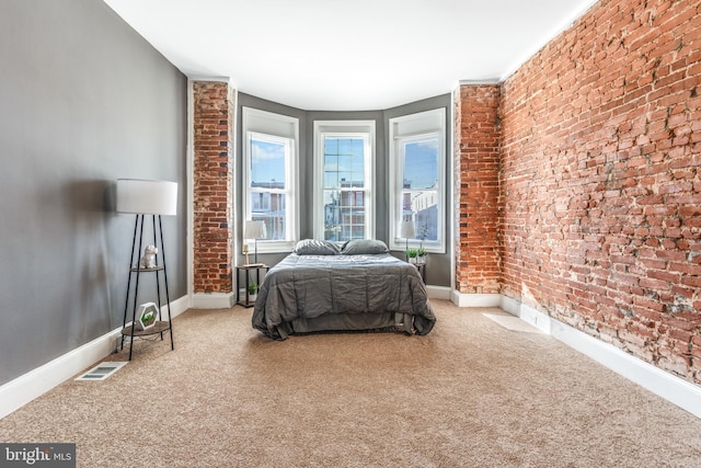 bedroom with brick wall and carpet